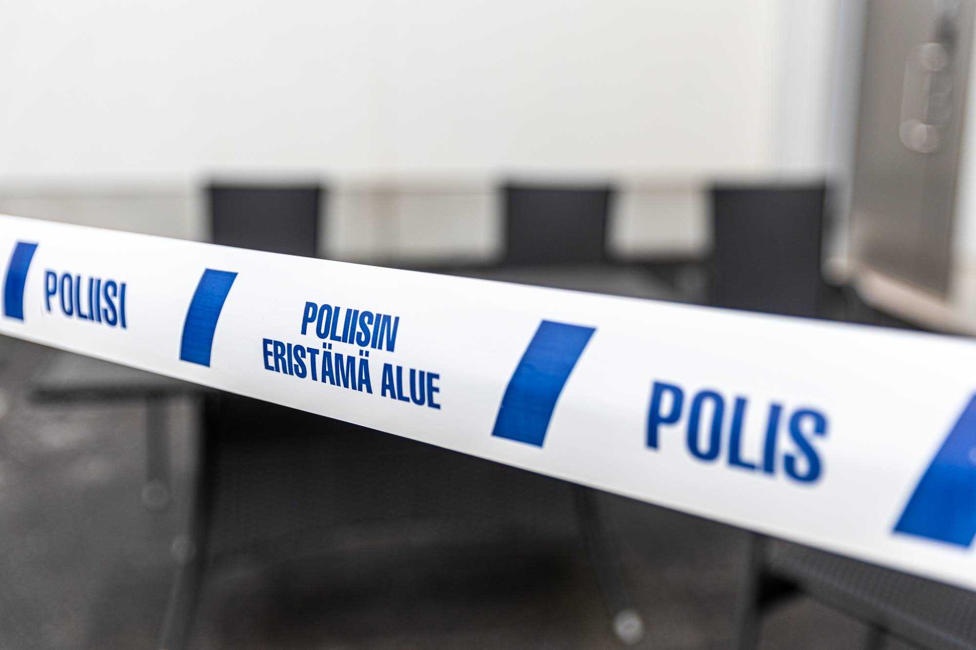 A blue and white ribbon with the words Poliisi, Poliisin eristämä alue (police cordoned off area) and Polis (Police).